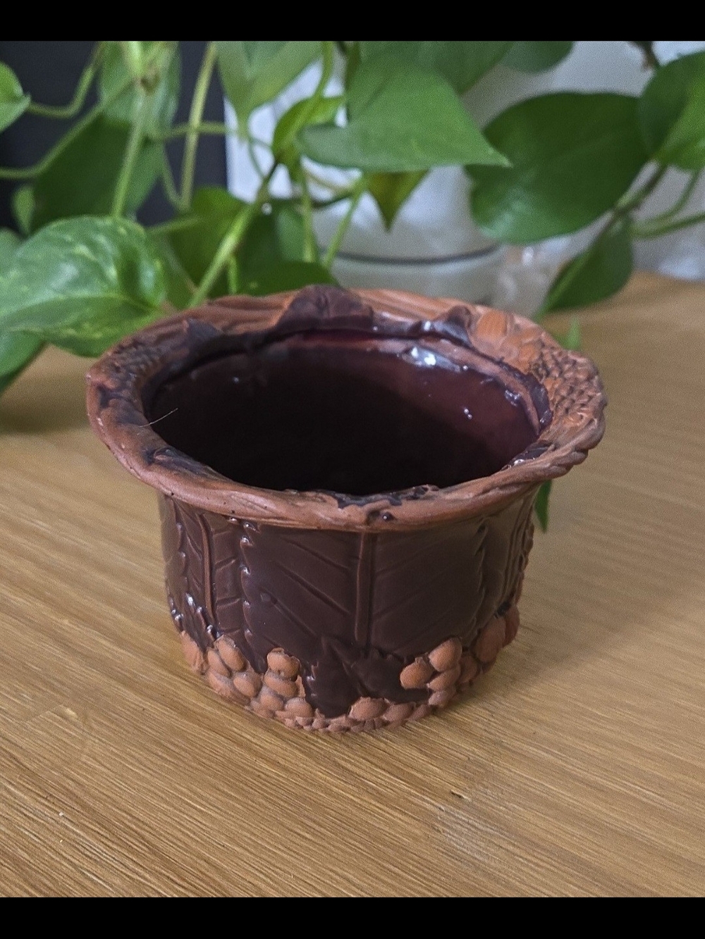 Claire Burke Designs terracotta pot with embossed leaves and grapes.